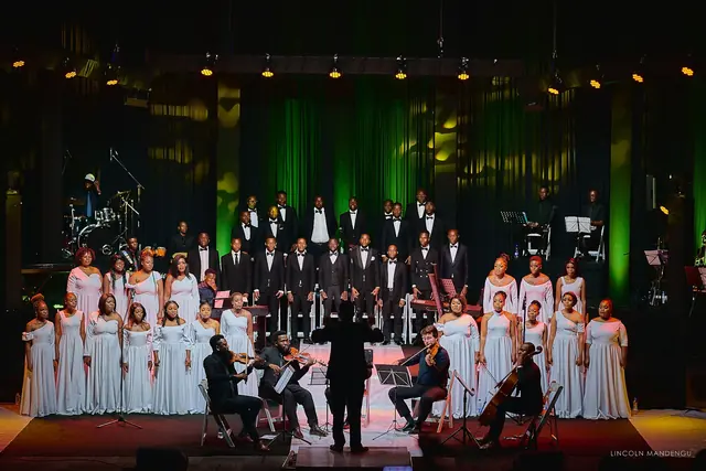 The full choir and string quartet under green stage light