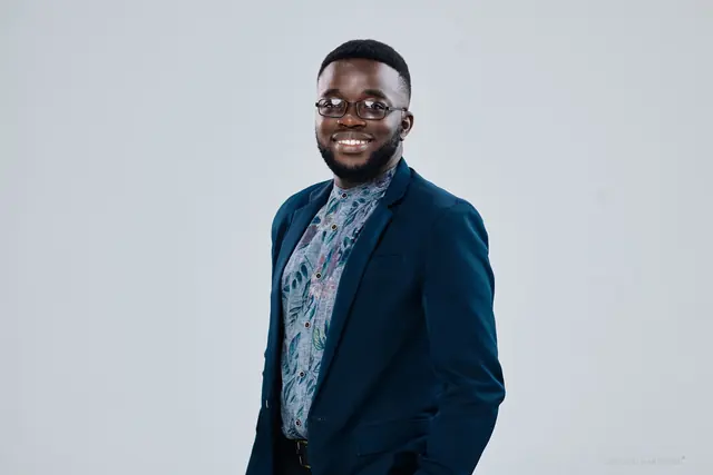 Tinashe Jera in a navy blazer, studio portrait