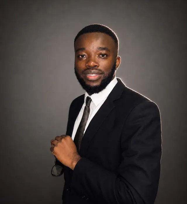 Tinashe Jera in a dark suit, studio portrait